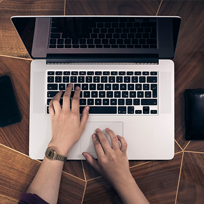 Hands over a Macbook